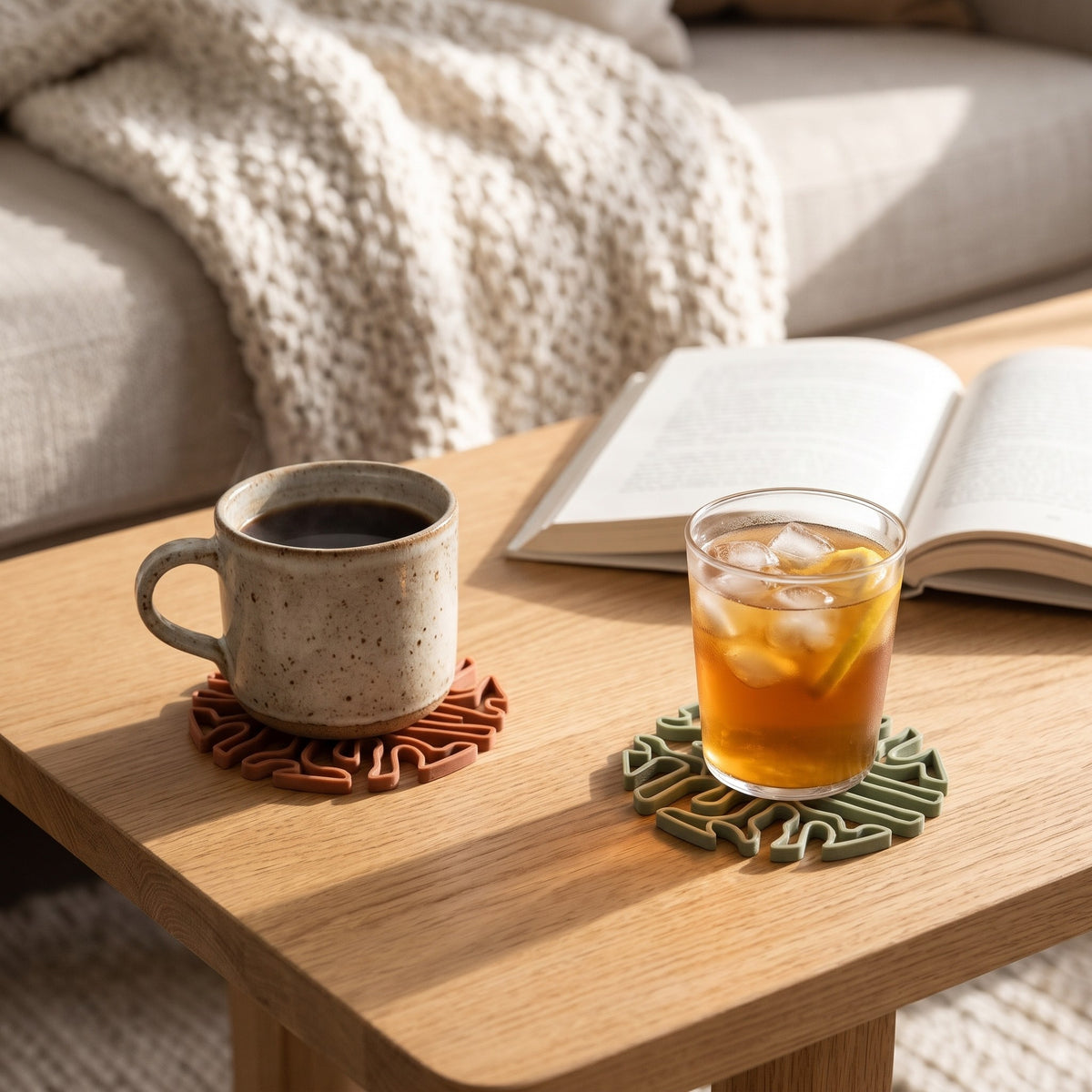 Coasters under a coffee mug and a glass of iced tea on a coffee table